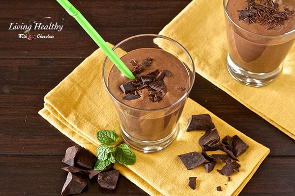 overhead shot of creamy thick mint chocolate milkshake on yellow napkin with bits of chocolate and piece of mint