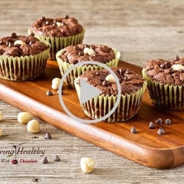 five chocolate hazelnut nutella muffins on cutting board with loose nuts sprinkled on and around cutting board