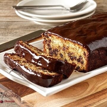 Paleo chocolate chip bread loaf with two slices cut and two plates in background
