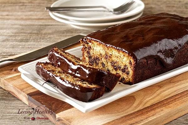 Paleo chocolate chip bread loaf with two slices cut and two plates in background