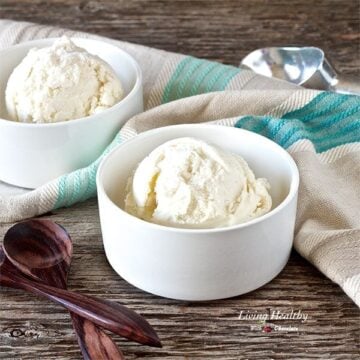 two small white serving bowls with paleo lychee ice cream and wooden spoons to the left