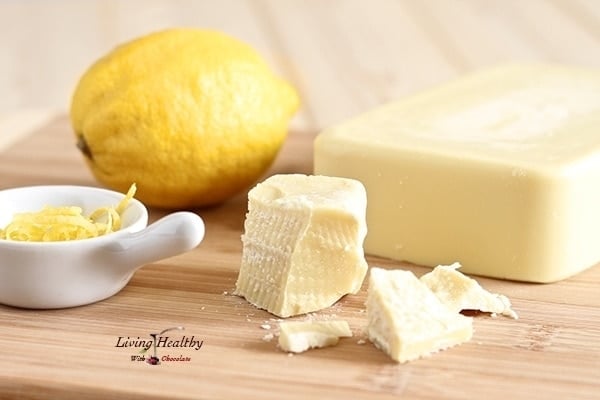 brick of cacao butter with lemon and small dish with shaved lemon zest in background for making white chocolate lemon mousse