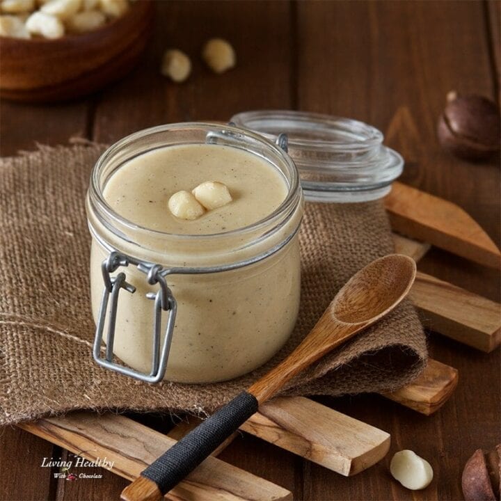 jar of homemade white chocolate macadamia nut butter with small wooded spoon in foreground
