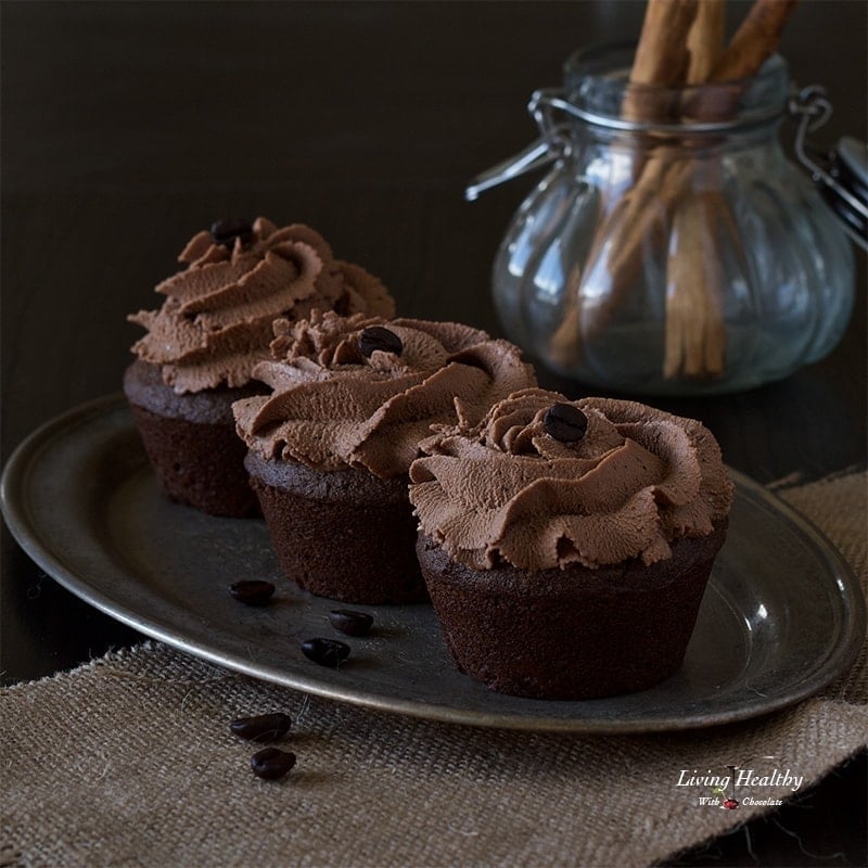 tray of cinnamon mocha cupcakes with a glass jar filled with cinnamon sticks in background