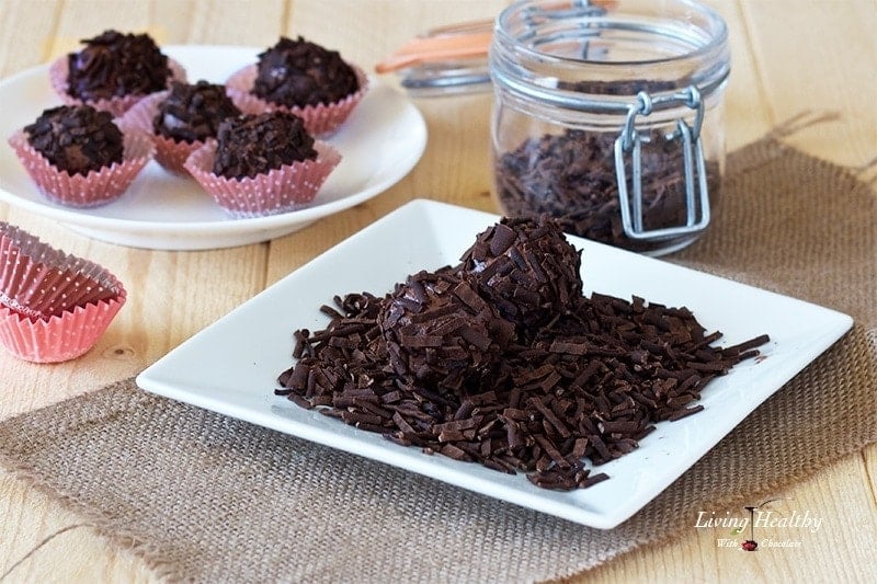 plate of chocolate truffles covered in chocolate sprinkles with more truffles in background