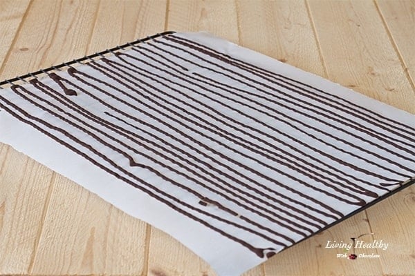 parchment paper covered in rows of chocolate for making chocolate sprinkles