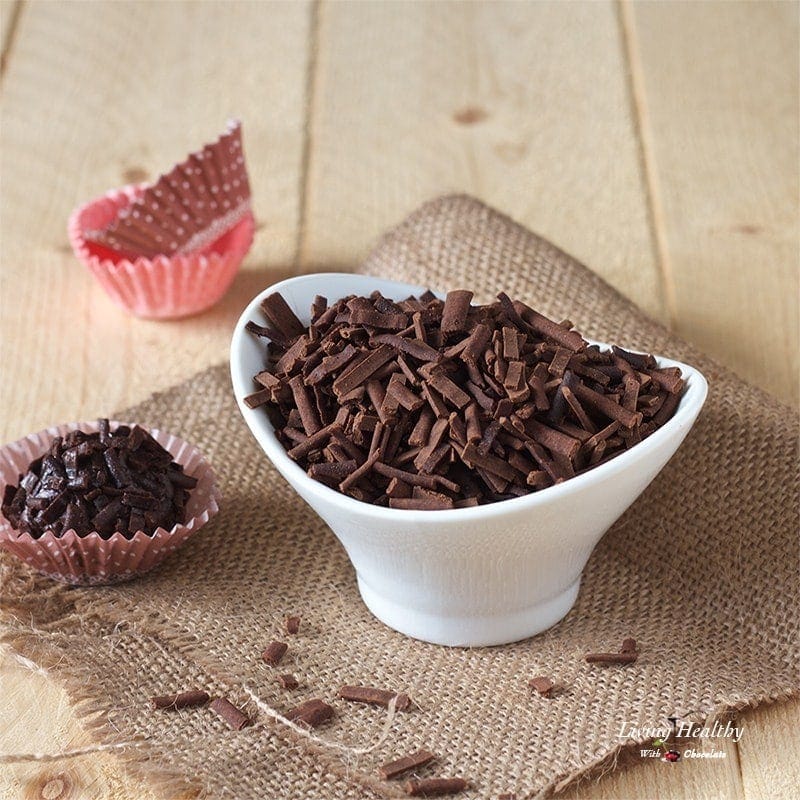 white bowl filled with homemade chocolate sprinkles and one chocolate truffle to the left