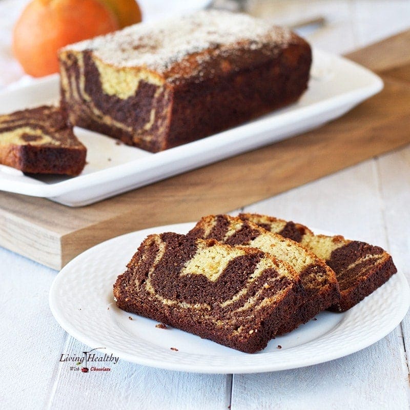 Three slices of cake on a plate and a whole cake in the background