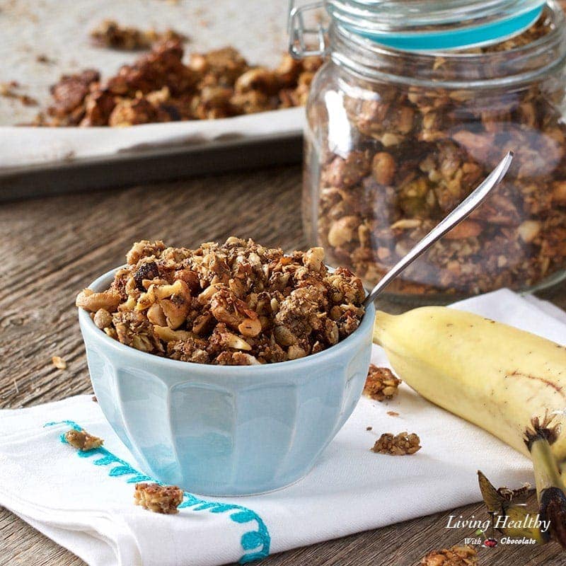 bowl of banana granola with a spoon and a jar of granola and a banana in the background