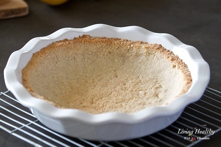 close up of a lemon cream pie crust in a baking dish on a cooling rack