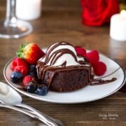 molten lava brownie plated with fresh berries and topped with a scoop of ice cream drizzled with chocolate