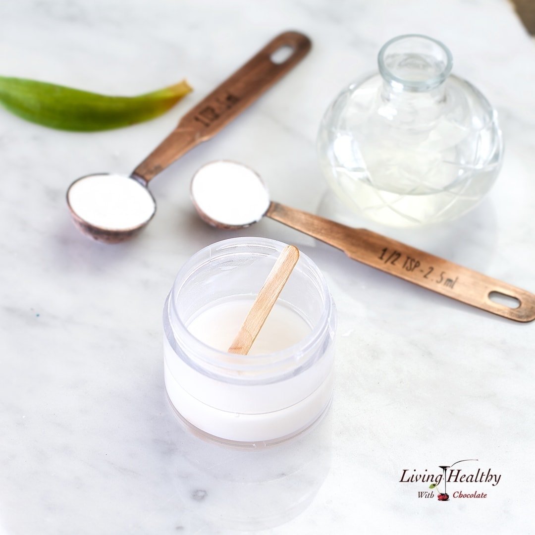 ingredients for making homemade natural deodorant in glass jar and brass teaspoons and plastic container