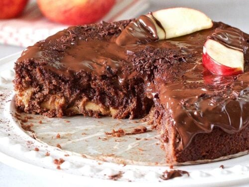 Apple chocolate cake topped with slices of apple and drizzled in chocolate sauce