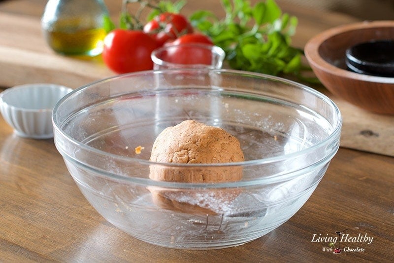 a large glass bowl with cassava flour dough in a ball for making crackers
