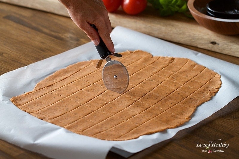 a sheet of cassava flour rolled out flat on a pan and cut into squares for crackers