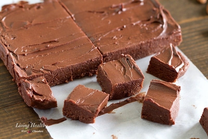 close up of no bake vegan brownies cut into squares on parchment paper