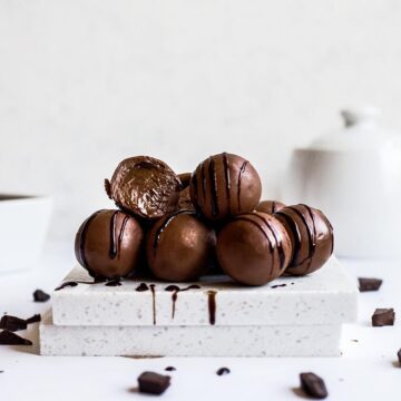 stack of chocolate hazelnut cream filled truffles with a white background