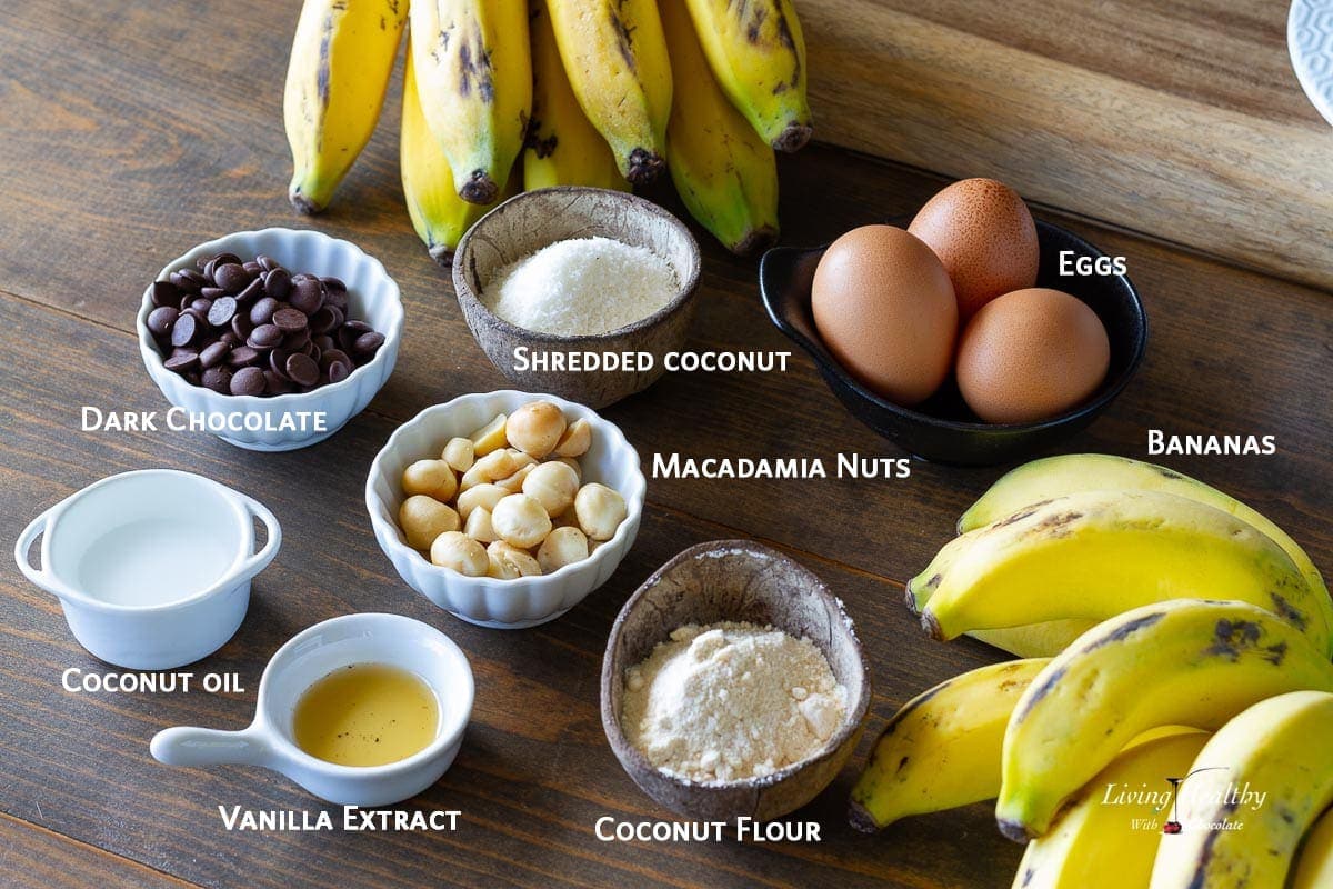 ingredients used to make coconut flour banana muffins displayed on wooden table in a variety of dishes and clearly labeled