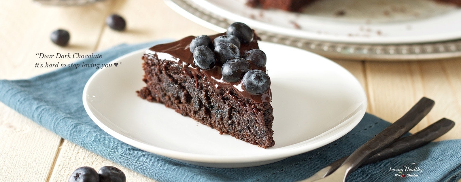 Chocolate cake with blueberries on top on a white plate