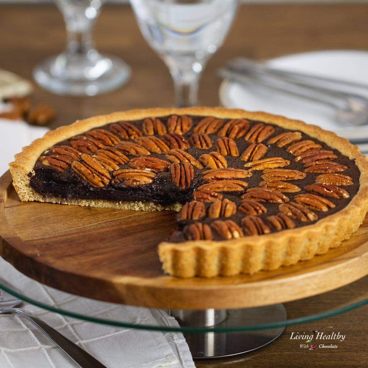 Chocolate Pecan Pie in a serving plate with a slice taken off.