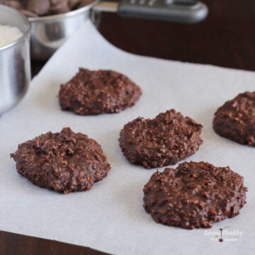 five no bake chocolate cookies on a piece of parchment paper.