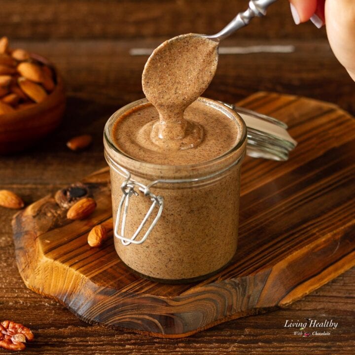 spoon dipped in a glass jar with homemade almond butter