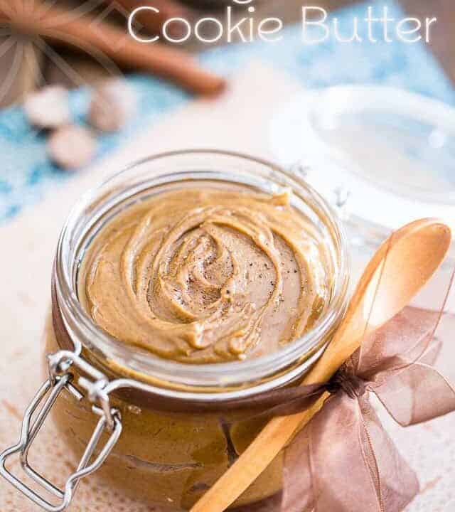 glass jar with nut butter inside and a wooden spoon next to it.