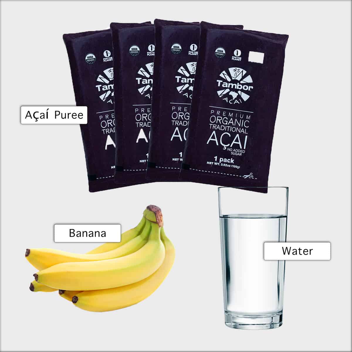 acai bowl ingredients containing four acai packages a bunch of bananas and a glass of water on a white background